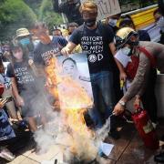 Portrait du general prayut chan o cha brule tandis qu un soldat tente d etendre l incendie qui menace la monarchie