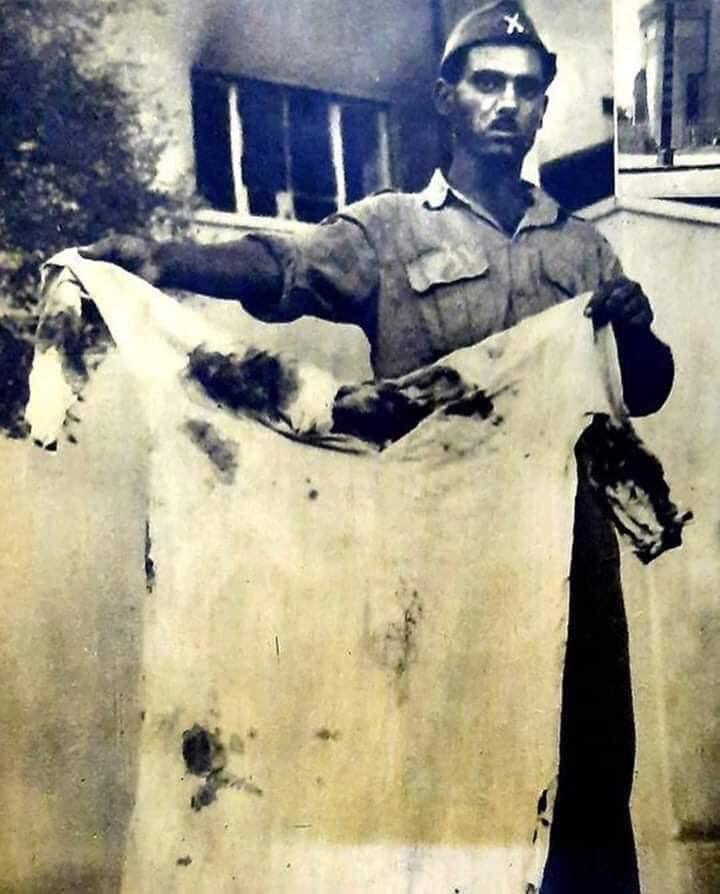 Un soldat exhibe les vêtements du roi faysal ii
